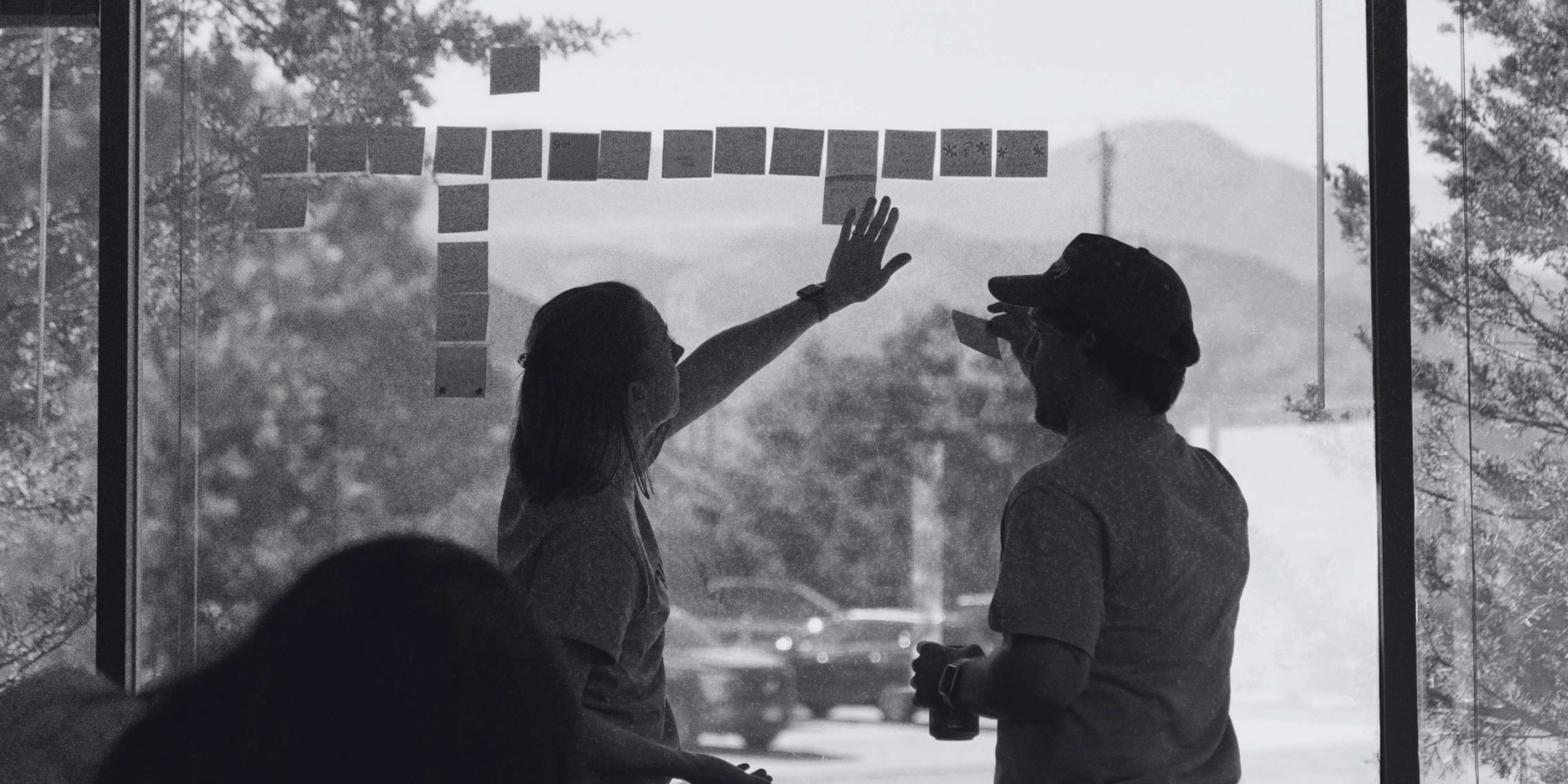 Black and white photo of two members of the Builder Funnel team going over some marketing strategy.